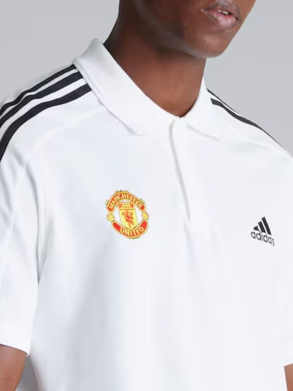 White polo shirt with Manchester United and Adidas logos on a gray background